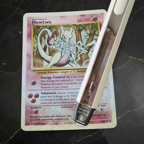 Carta Mewtwo con penna su sfondo marmo